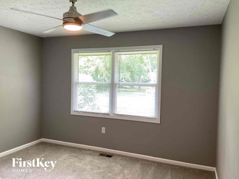 a bedroom with a window and a ceiling fan