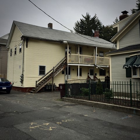 A two-story house with a car parked in front.