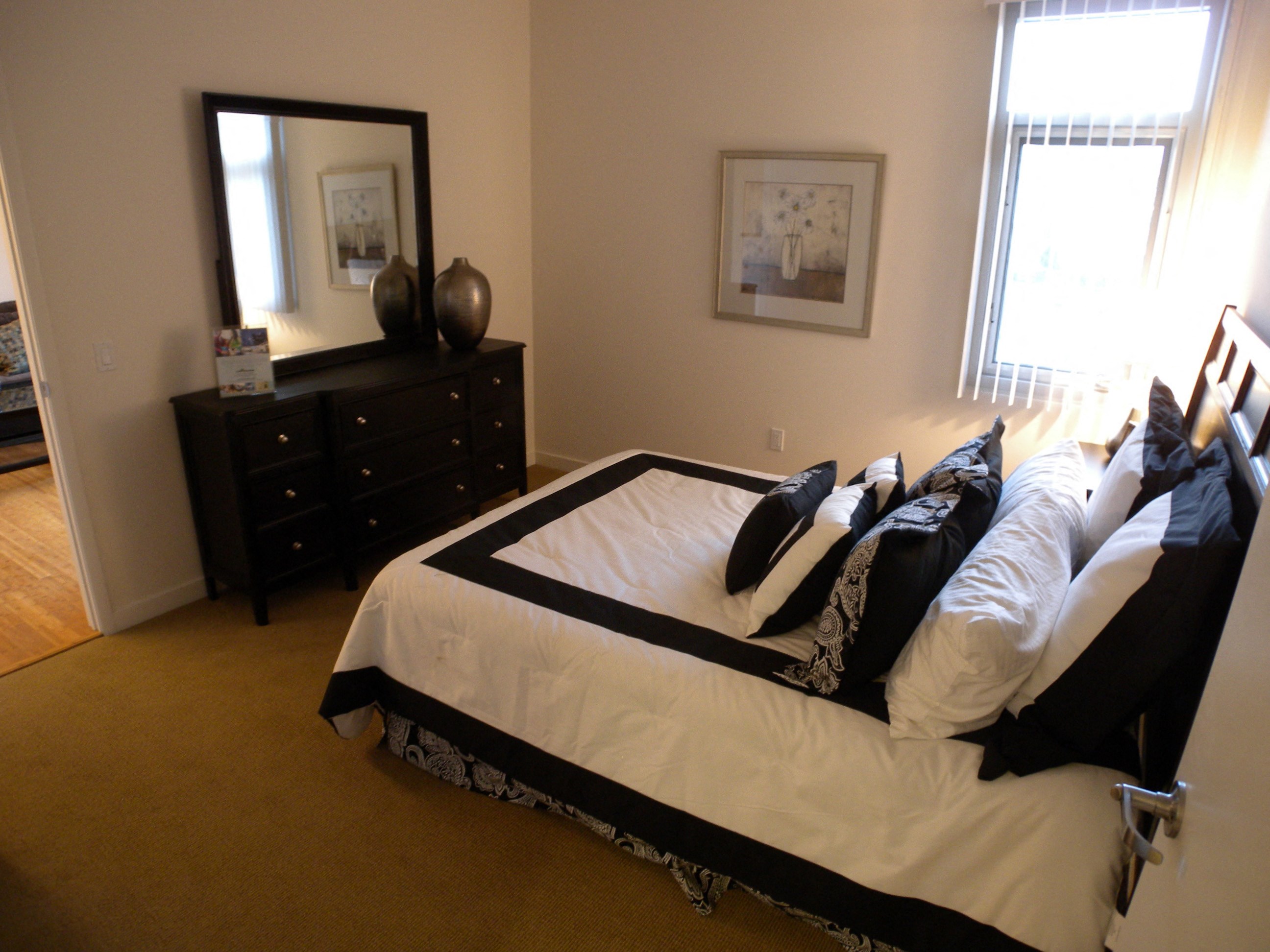 a bedroom with a bed with pillows and a dresser and a mirror