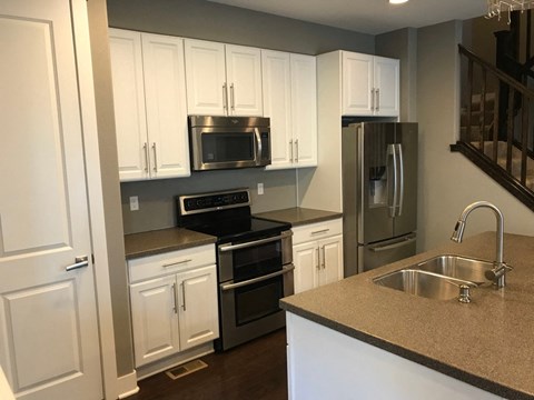 a kitchen with white cabinets and stainless steel appliances