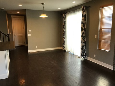 an empty living room with hard wood floors and a window