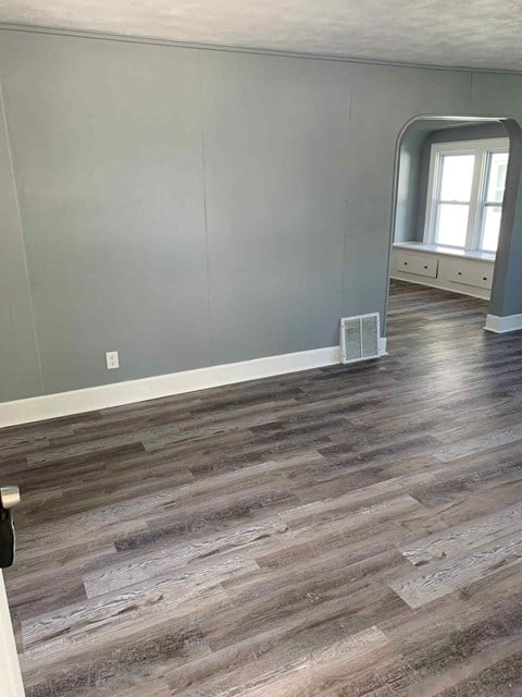 a living room with gray walls and wood floors