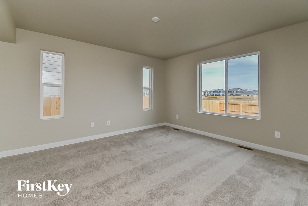 a spacious living room with carpeted floors and a large window