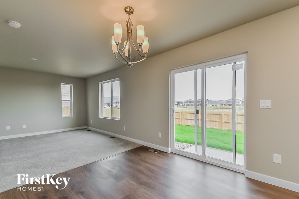 an empty living room with sliding glass doors to the backyard