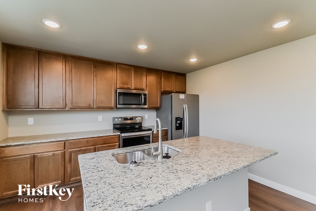 an expansive kitchen with granite countertops and wooden cabinets and stainless steel appliances