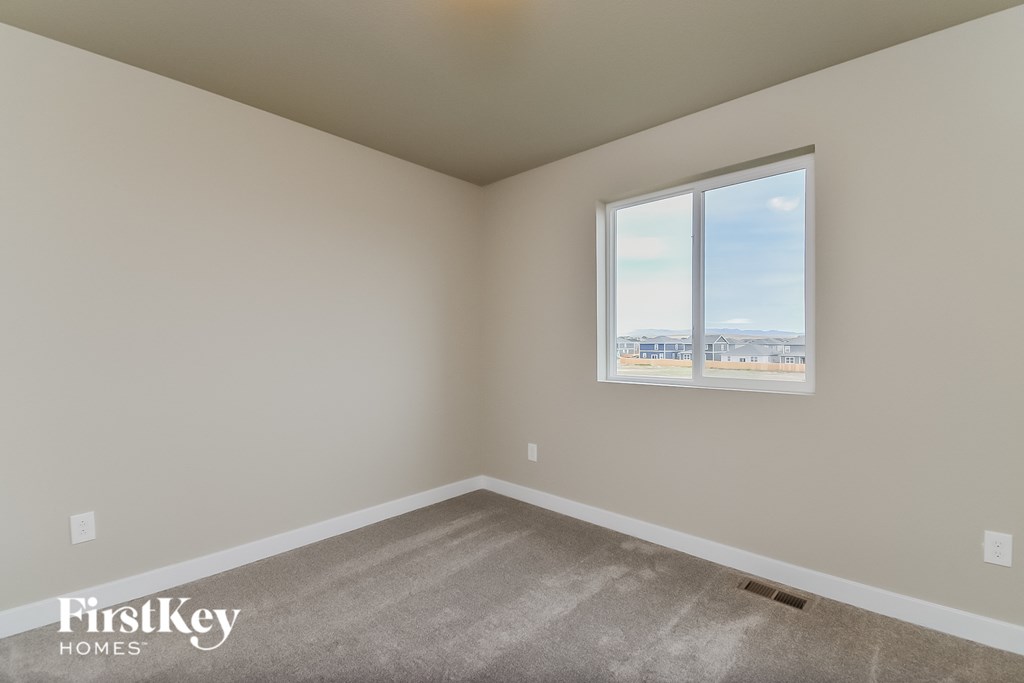a room with a window and a carpeted floor