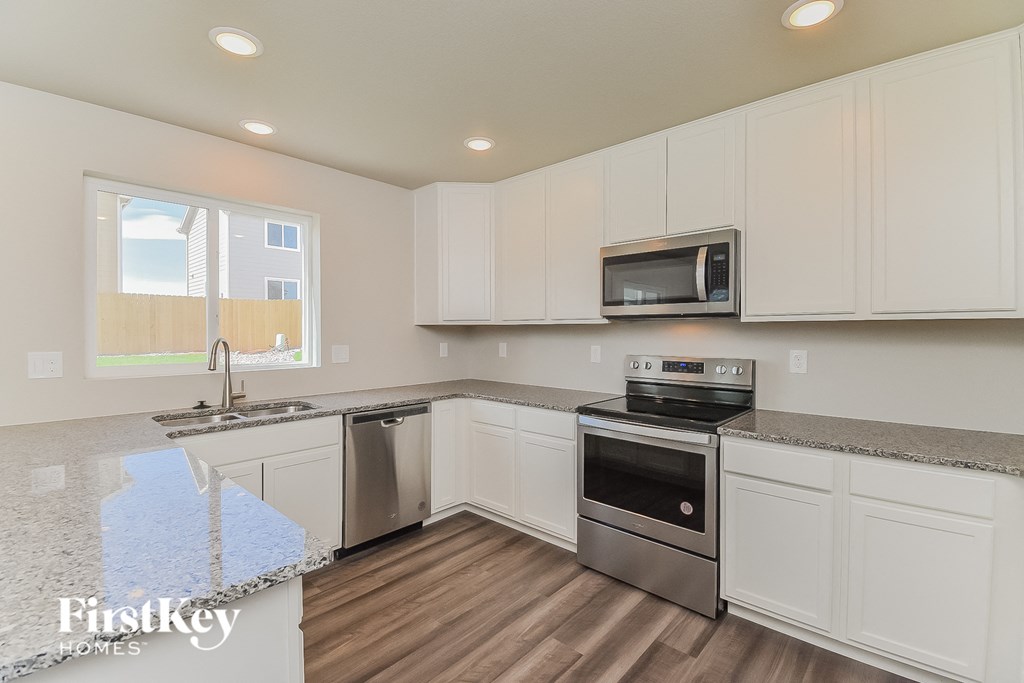 A kitchen with white cabinets and a stainless steel dishwasher.