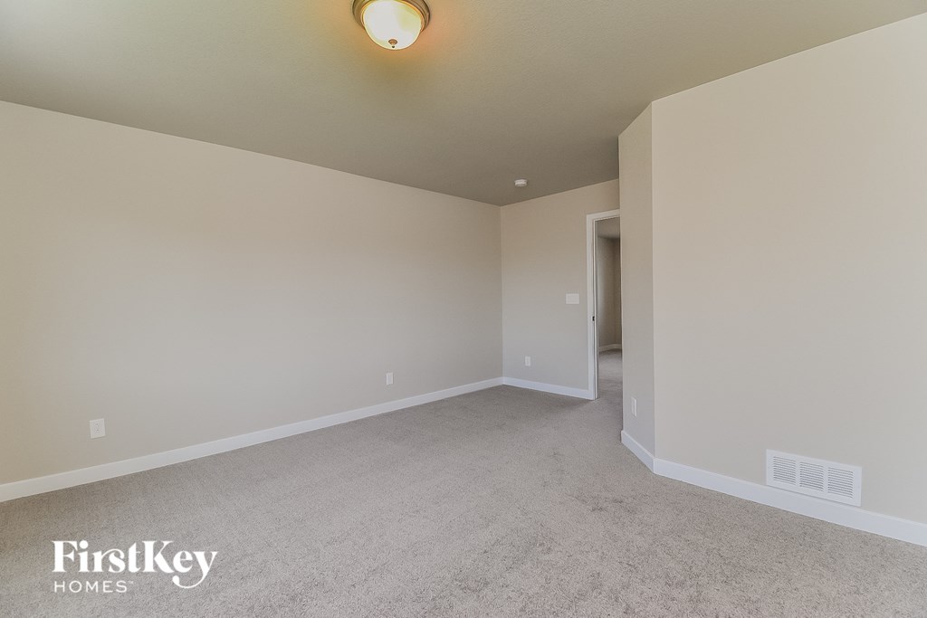 A room with a carpet floor and a light on the ceiling.