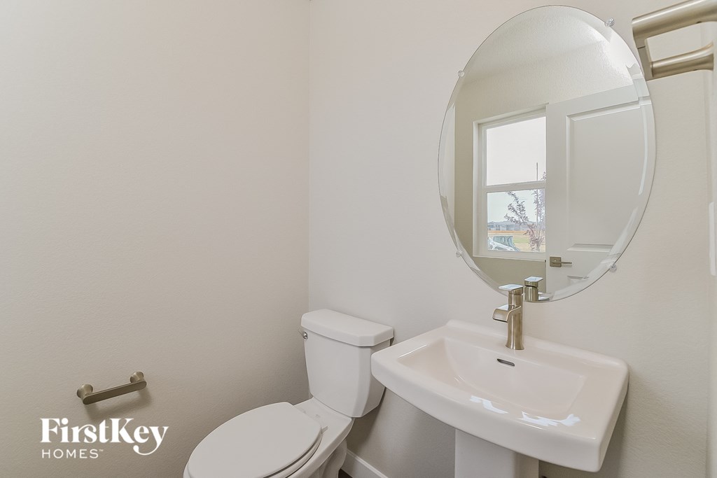 A white toilet and sink in a bathroom.