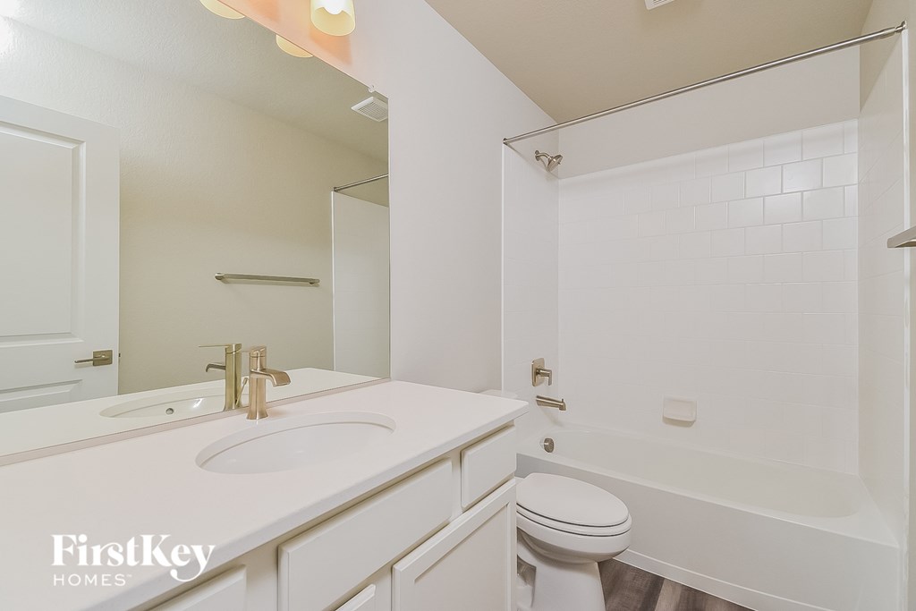 A white bathroom with a sink, toilet and bathtub.