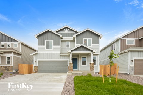 a large gray house with a driveway in front of it