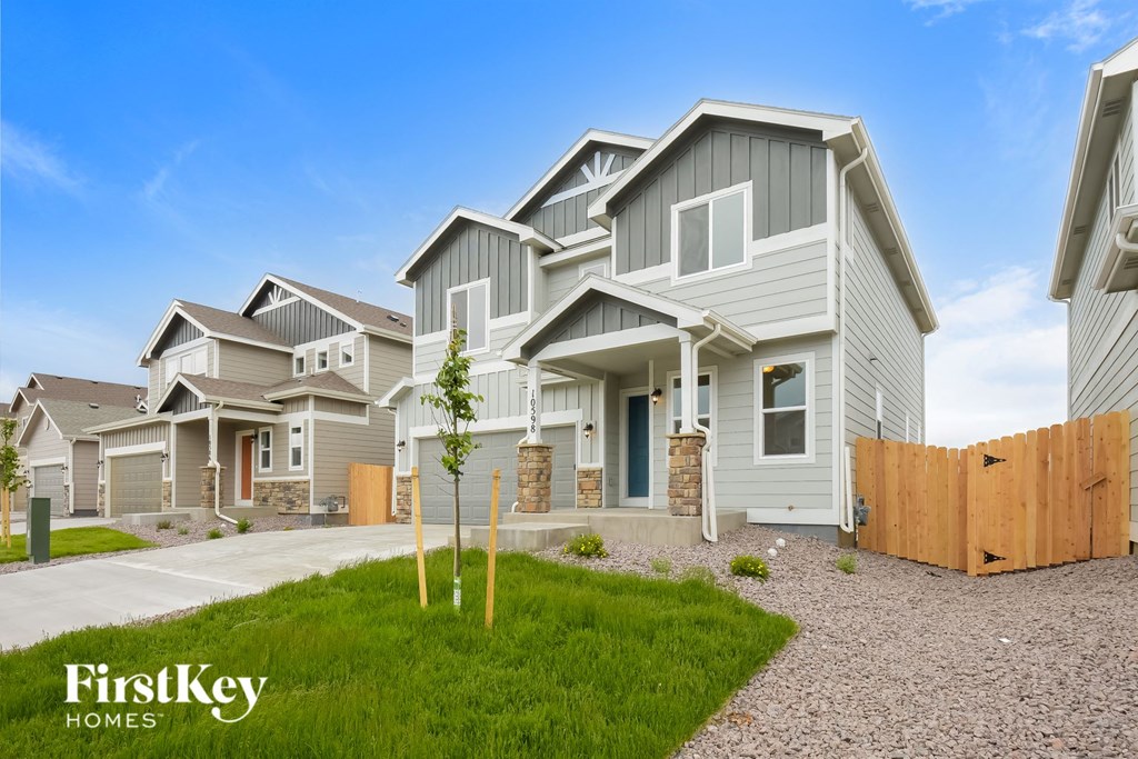 a row of houses with a yard and a wooden fence