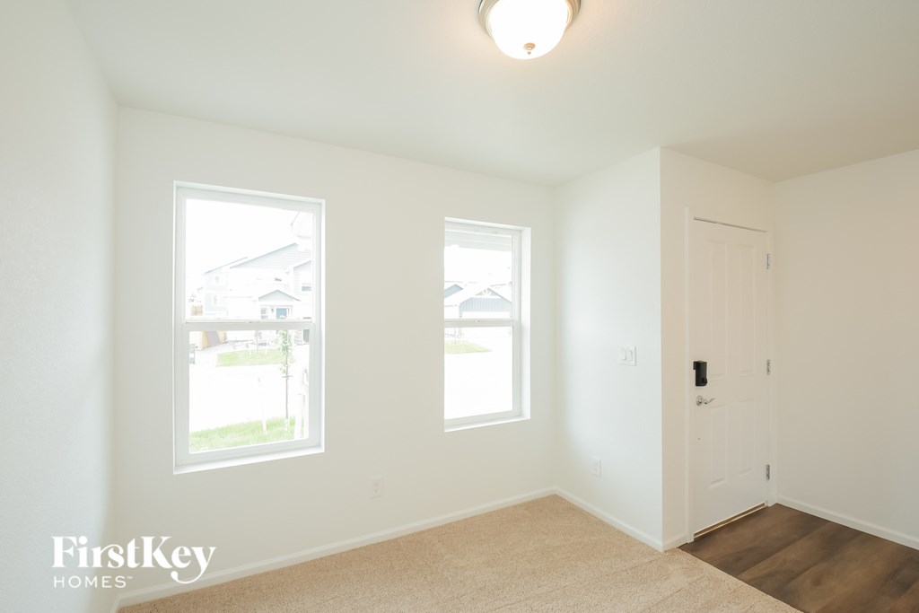 a bedroom with two windows and a door