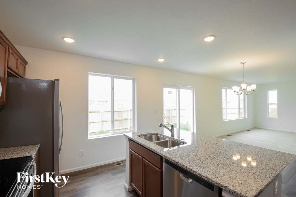 a kitchen with a granite counter top and a stainless steel refrigerator