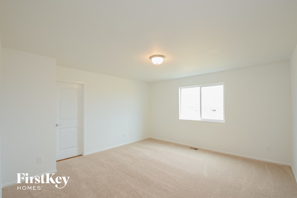 a bedroom with white walls and a white door and window