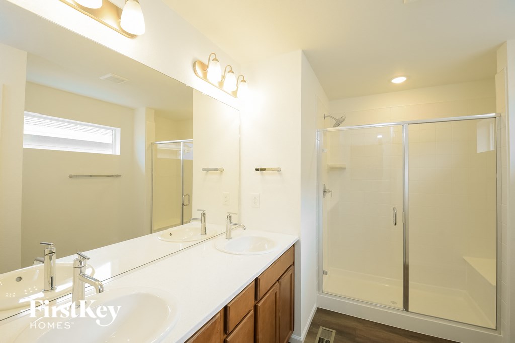 a bathroom with two sinks and a shower