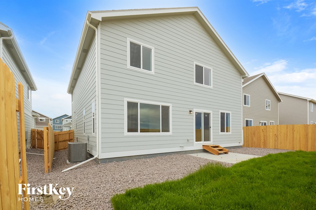a white house with a yard and a wooden fence