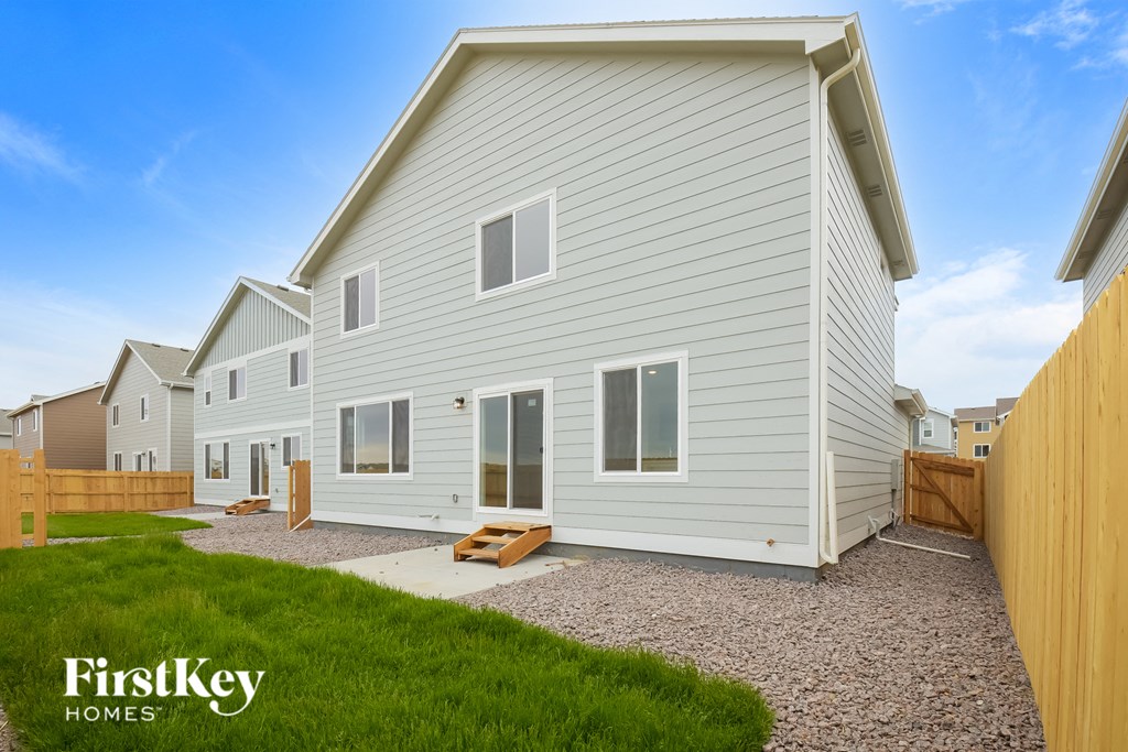 a white house with a yard and a wooden fence