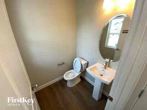 a bathroom with a toilet and a sink and a mirror