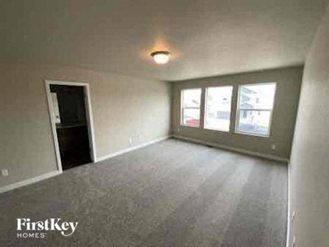 an empty living room with a door to a window