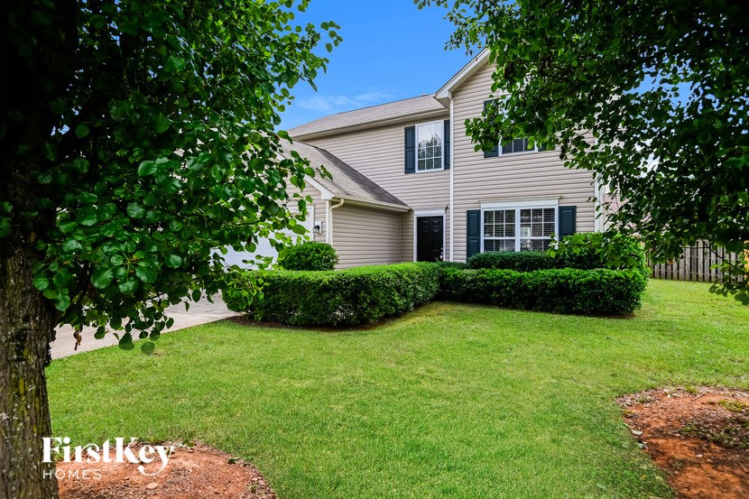 a house with a lawn and trees in front of it