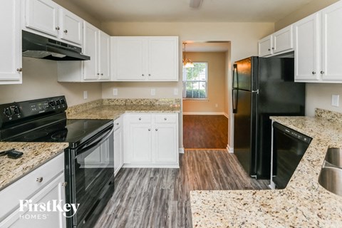 a kitchen with black appliances and white cabinets