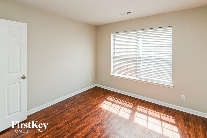 the living room of a home with wood floors and a window