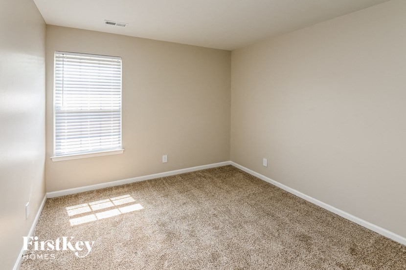 a empty room with a window and carpet