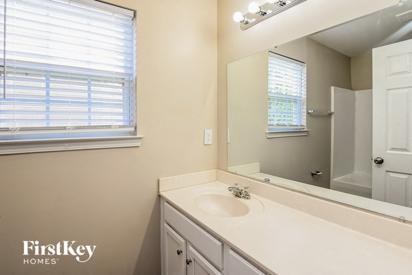 a bathroom with a sink and a mirror and a window