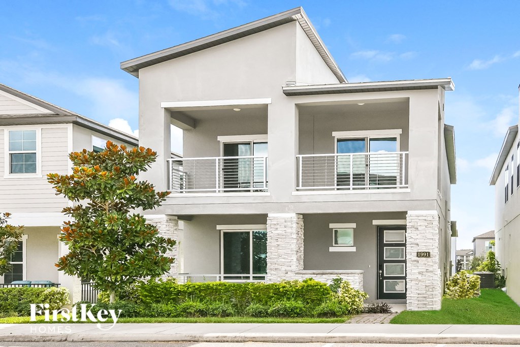 a white house with a tree in front of it