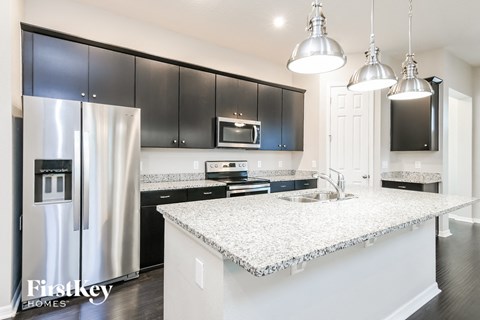 a kitchen with black cabinets and a white counter top