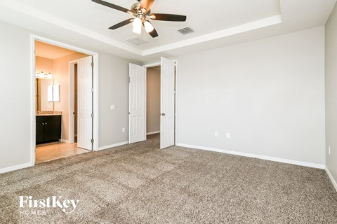 a living room with carpet and a ceiling fan