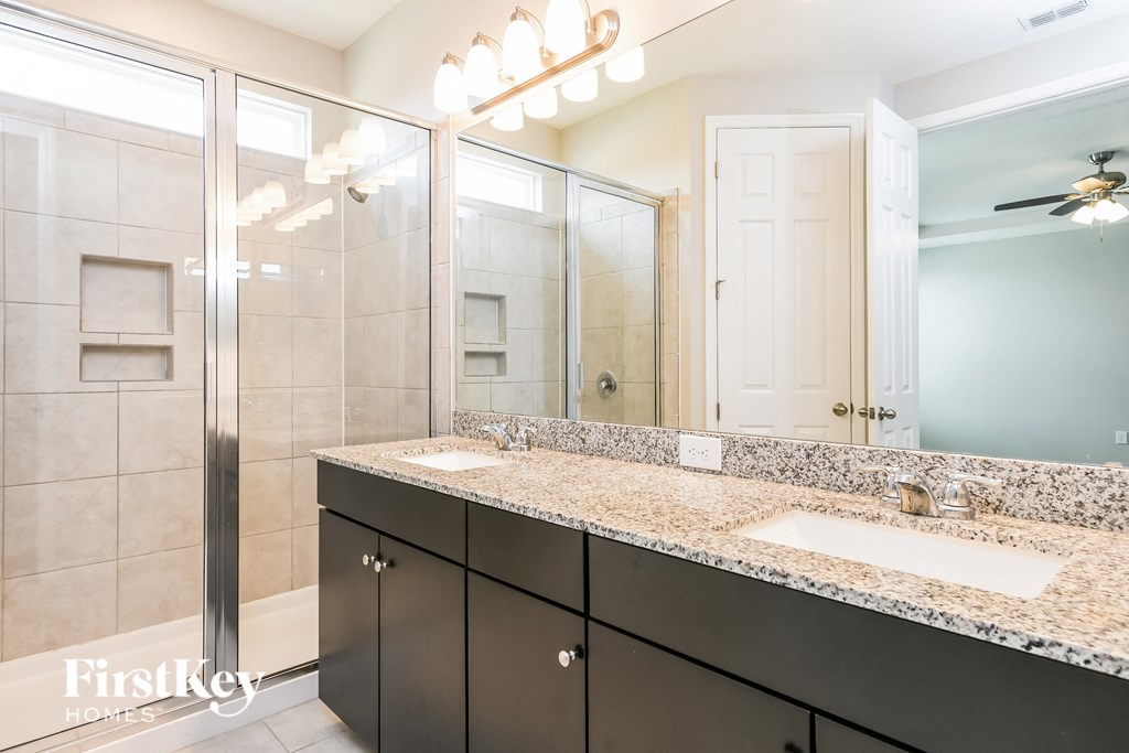 a bathroom with two sinks and a shower