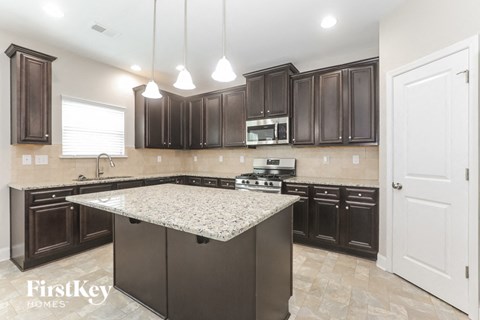 a kitchen with dark wood cabinets and granite counter tops