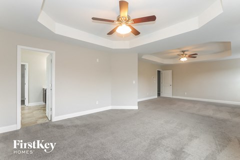 a living room with carpet and a ceiling fan