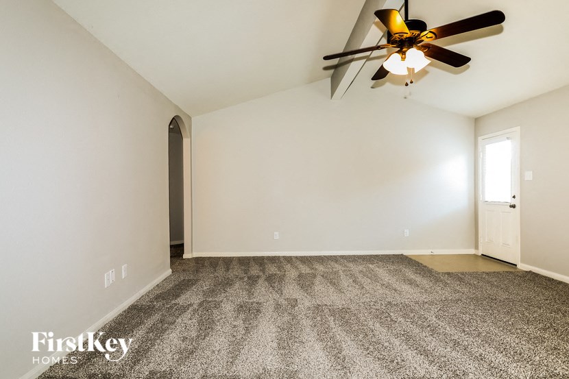 the living room of a house with a ceiling fan