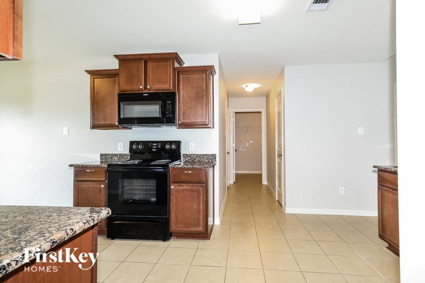 a kitchen with wood cabinets and a black stove and a microwave