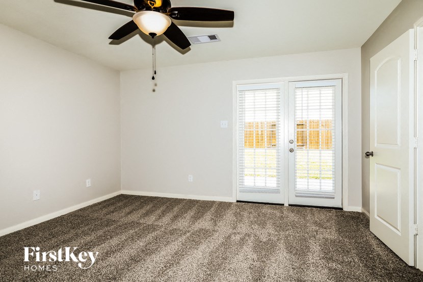 a living room with carpet and a ceiling fan