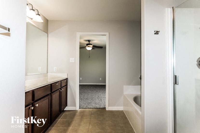 a bathroom with a tub and a sink and a mirror