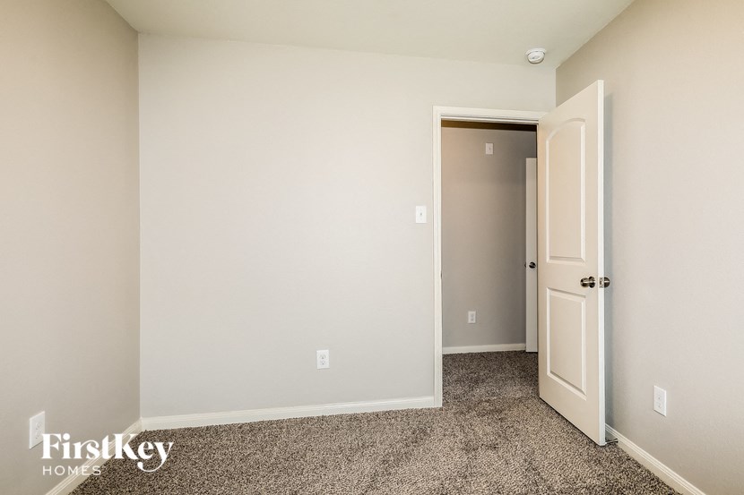 a bedroom with an open door and a carpeted floor