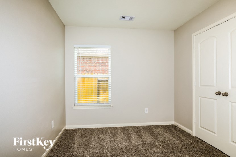 a empty room with carpet and a window