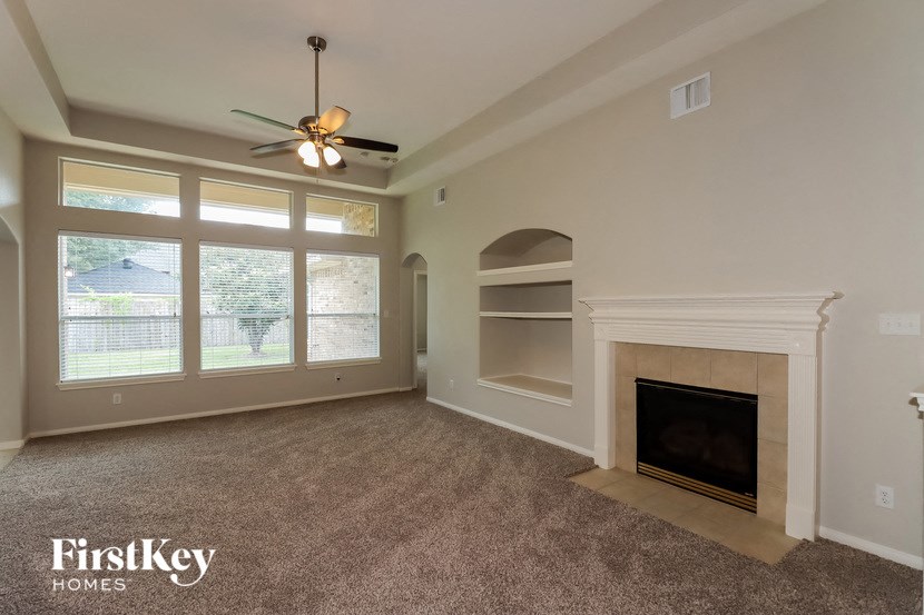 a living room with a fireplace and a ceiling fan