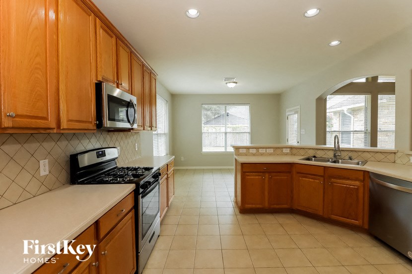 a kitchen with a stove and a sink and a microwave