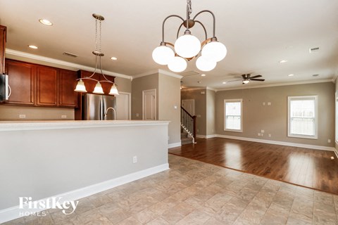 A well-lit kitchen with wooden cabinets and a tiled floor.