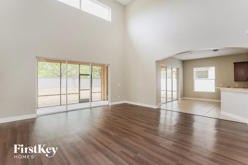 an empty living room with wood flooring and sliding glass doors