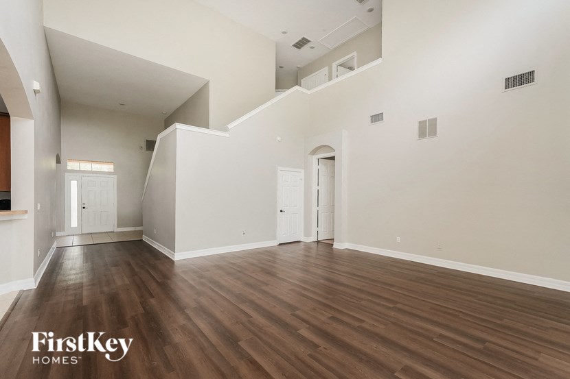 an empty living room with white walls and wood flooring