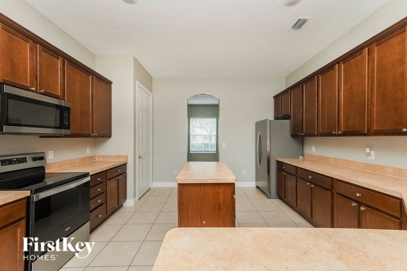 an empty kitchen with wooden cabinets and stainless steel appliances