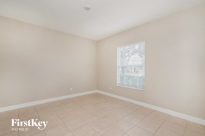 an empty room with a window and a tiled floor