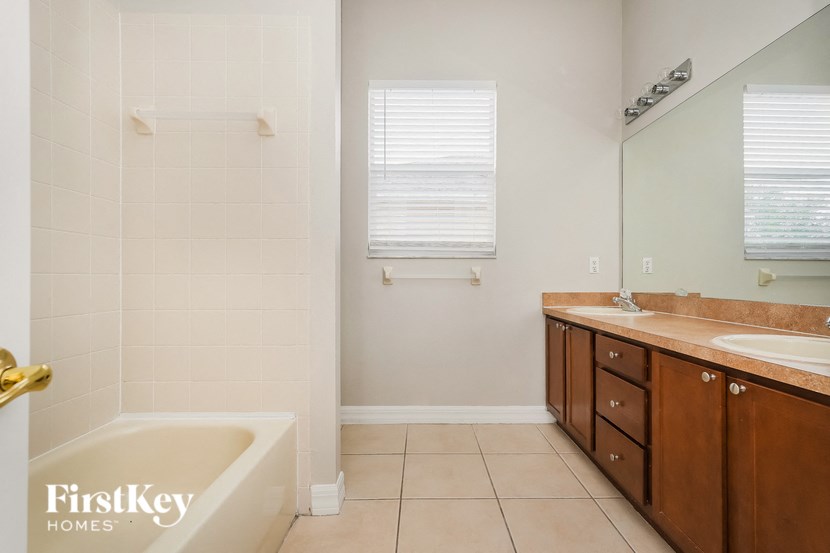 a bathroom with a bath tub and a sink and a mirror