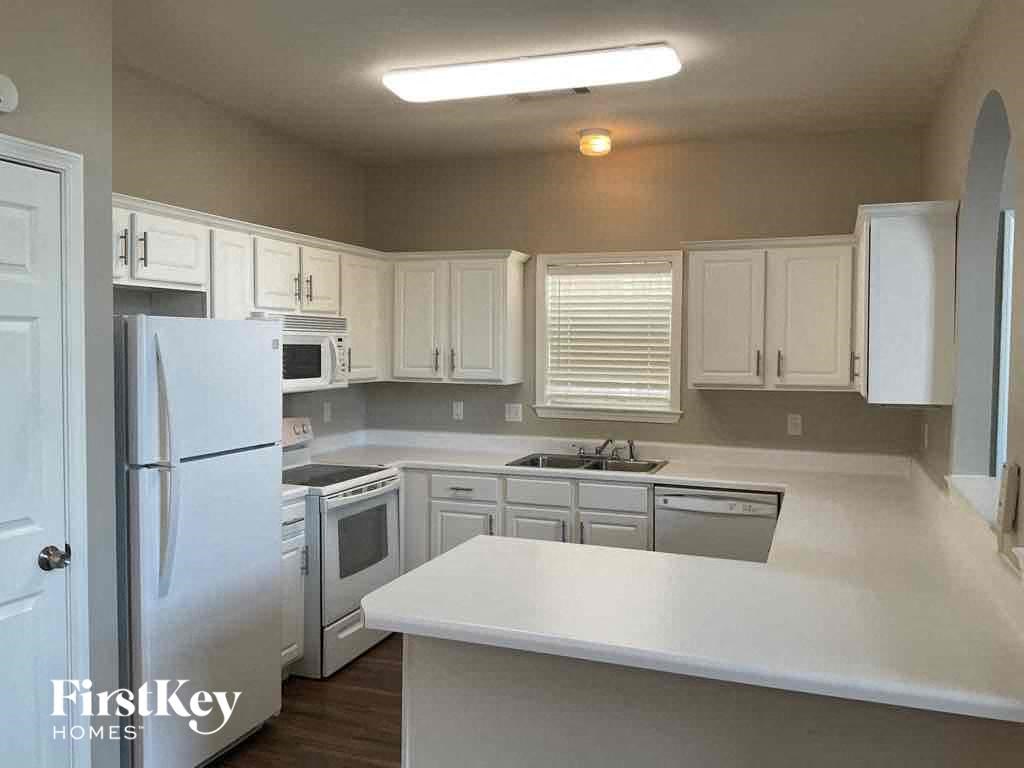 A kitchen with white appliances and cabinets.